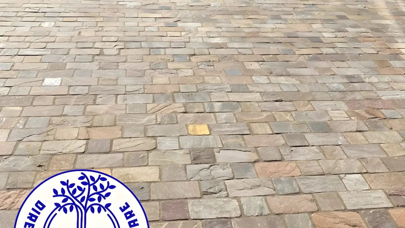 Driveway laid in tumbled block paving setts running up to a house