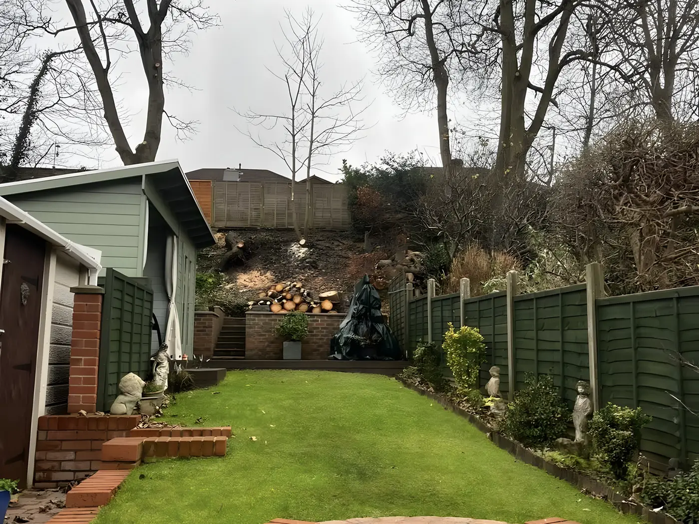 Rear garden with a curved brick retaining wall, steps and a newly laid lawn