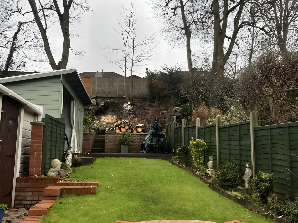 Rear garden with a curved brick retaining wall, steps and a newly laid lawn