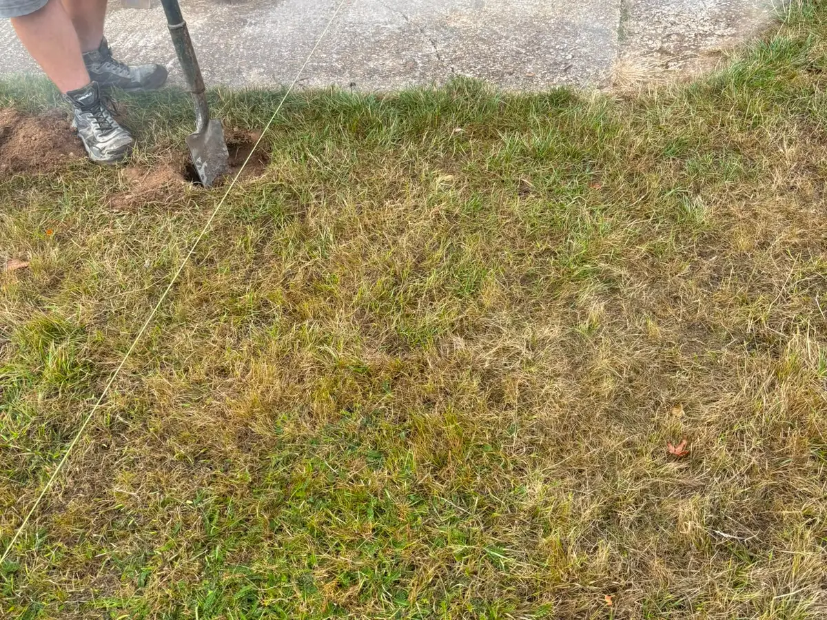 Setting out a new edge with a string line before breaking into the existing ground