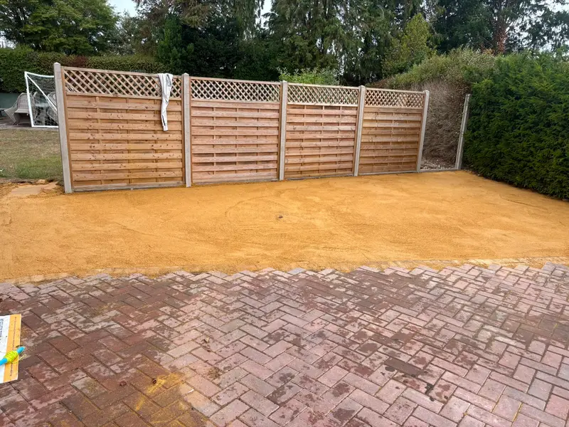 Driveway half finished, laid block paving meeting the screeded sand bed