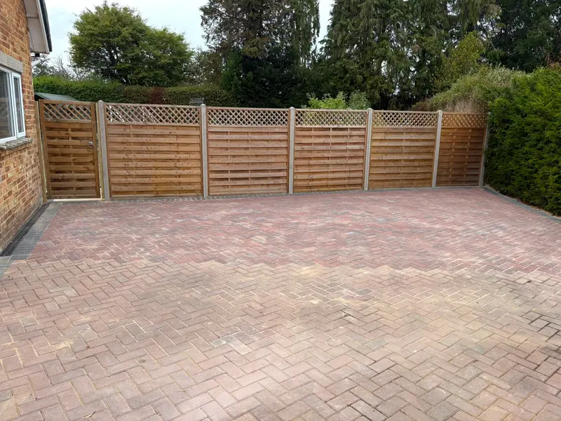 The finished block paved driveway, edged and swept, enclosed by the new fence